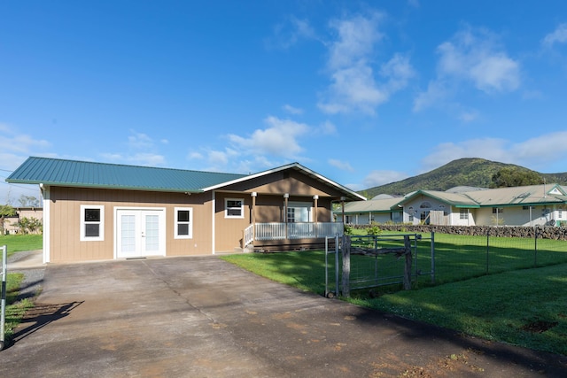 view of front facade featuring a mountain view, a front yard, and french doors