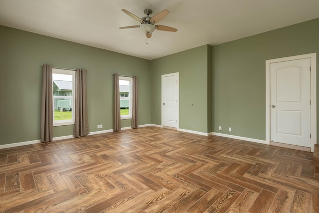 spare room featuring ceiling fan and dark parquet floors