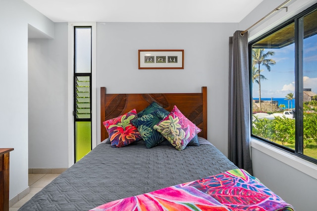 bedroom featuring tile patterned flooring and a water view