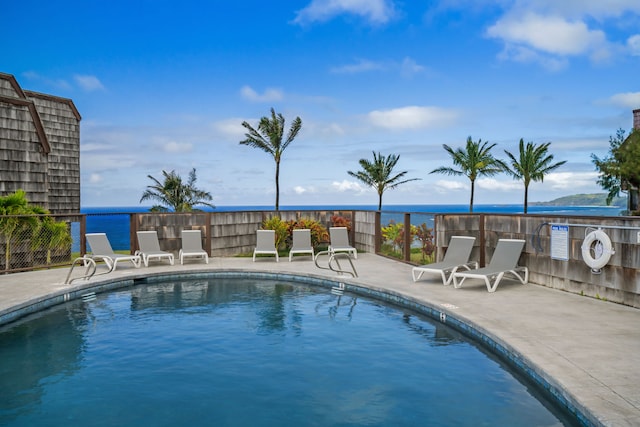 view of pool with a water view and a patio