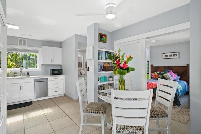 kitchen with white cabinetry, ceiling fan, stainless steel dishwasher, a breakfast bar area, and light tile patterned floors