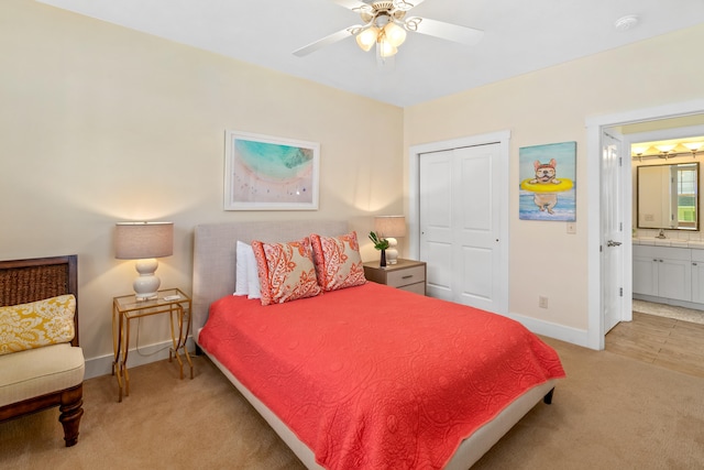 bedroom featuring ceiling fan, light carpet, connected bathroom, and a closet