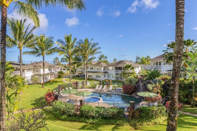 view of swimming pool with a community hot tub and a yard