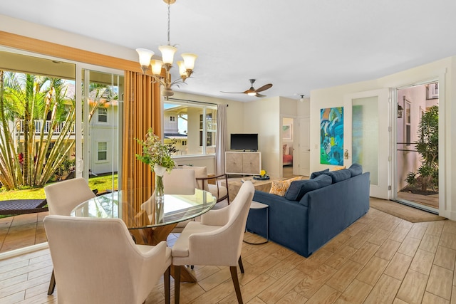 dining space with ceiling fan with notable chandelier