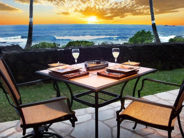 patio terrace at dusk featuring a water view