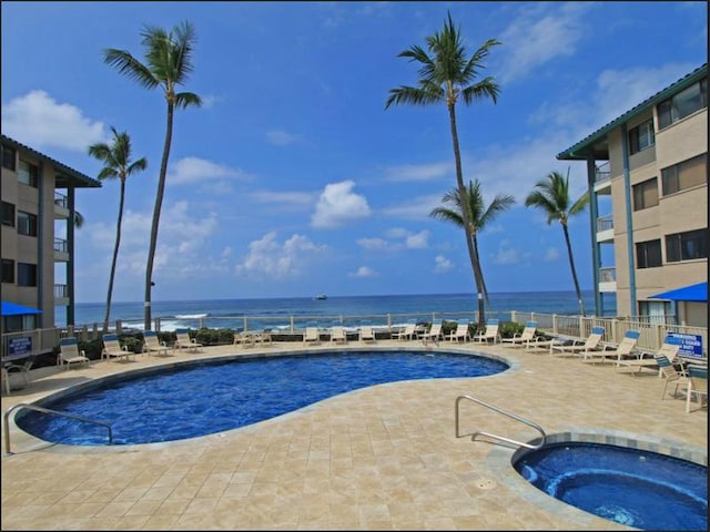 view of swimming pool featuring a patio, a water view, and a community hot tub