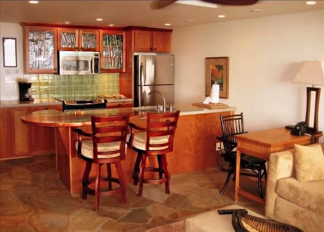 bar featuring tasteful backsplash, stainless steel appliances, and sink