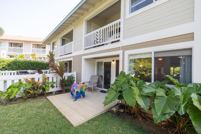 rear view of house featuring a patio and a balcony