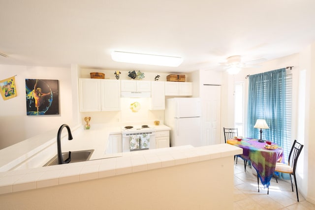 kitchen featuring white cabinets, white refrigerator, and tile countertops