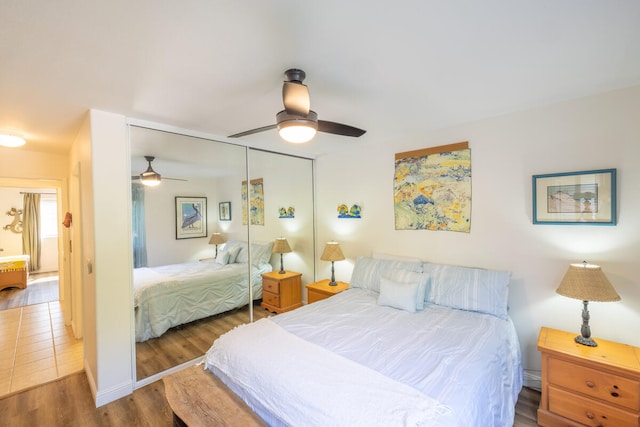 bedroom featuring ceiling fan, dark hardwood / wood-style flooring, and a closet