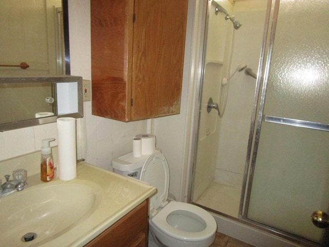 bathroom featuring toilet, an enclosed shower, and vanity