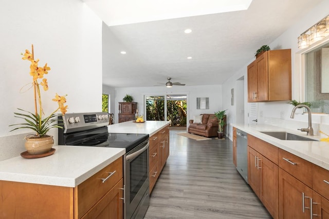 kitchen featuring sink, a center island, ceiling fan, light hardwood / wood-style flooring, and appliances with stainless steel finishes