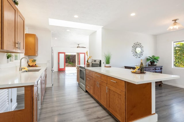 kitchen featuring sink, electric stove, light wood-type flooring, and ceiling fan