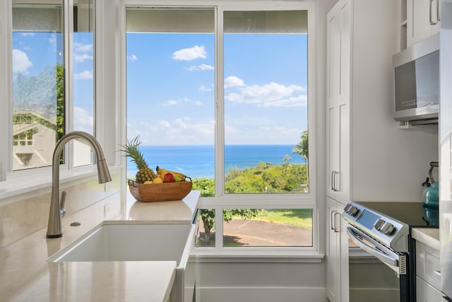 kitchen featuring a water view, white cabinetry, sink, and appliances with stainless steel finishes