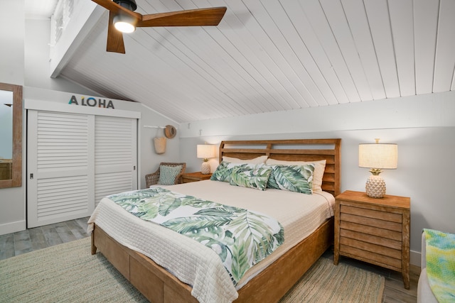 bedroom with ceiling fan, a closet, light hardwood / wood-style floors, and lofted ceiling