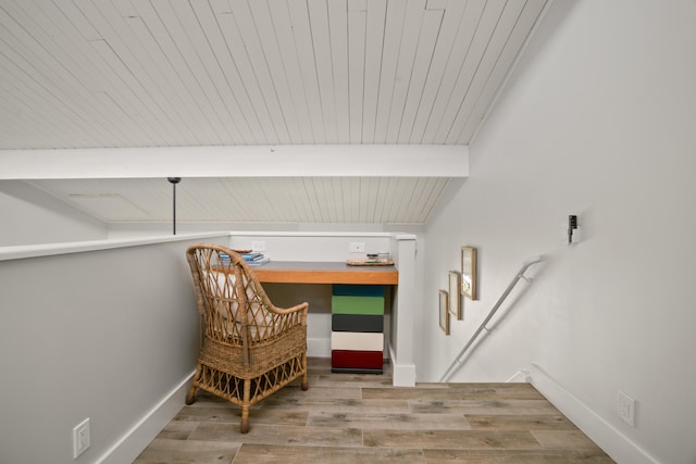 living area featuring beamed ceiling, light wood-type flooring, and wooden ceiling