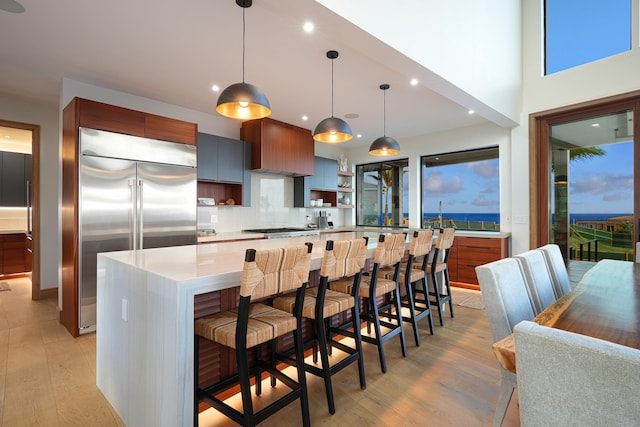 kitchen featuring a center island, hanging light fixtures, stainless steel appliances, tasteful backsplash, and a breakfast bar