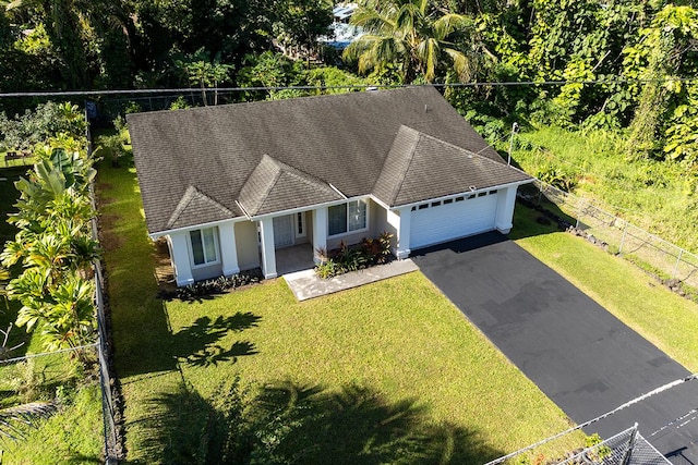 ranch-style house featuring a garage and a front lawn