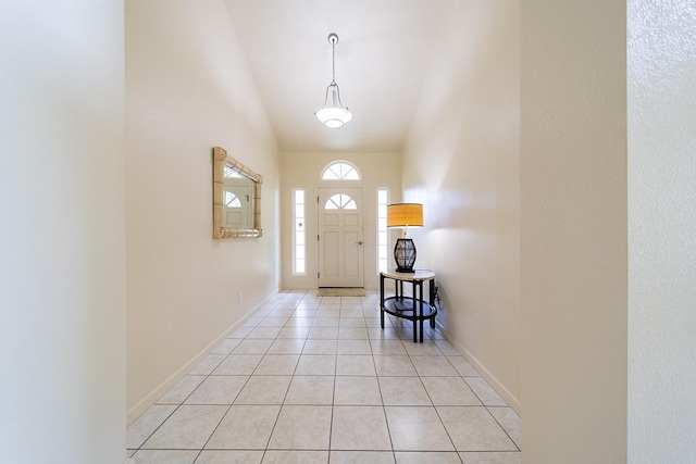 foyer featuring light tile patterned flooring and high vaulted ceiling