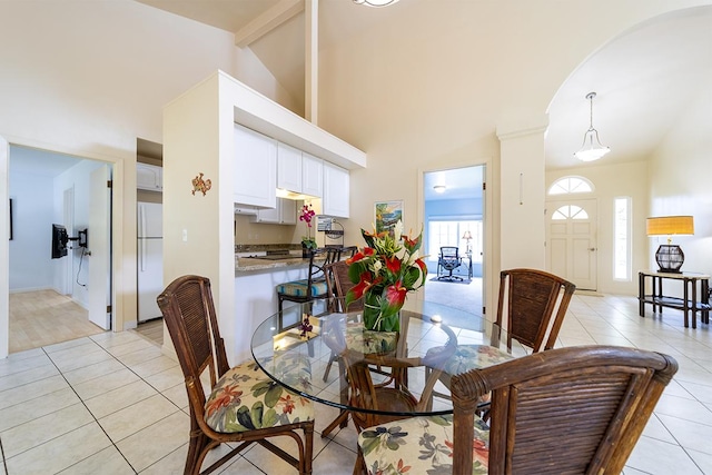 dining room with high vaulted ceiling, beamed ceiling, and light tile patterned flooring