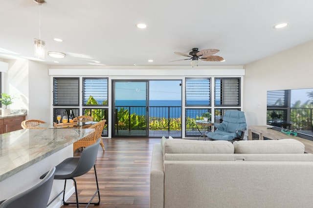 living room featuring ceiling fan, dark hardwood / wood-style floors, and a healthy amount of sunlight