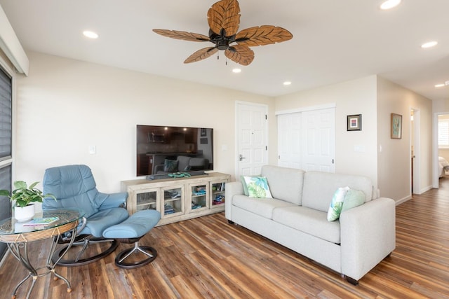 living room featuring ceiling fan and dark hardwood / wood-style flooring