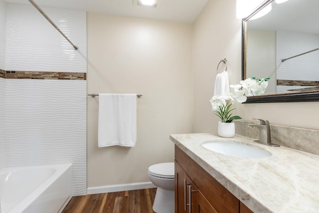 full bathroom featuring toilet, vanity, wood-type flooring, and bathing tub / shower combination