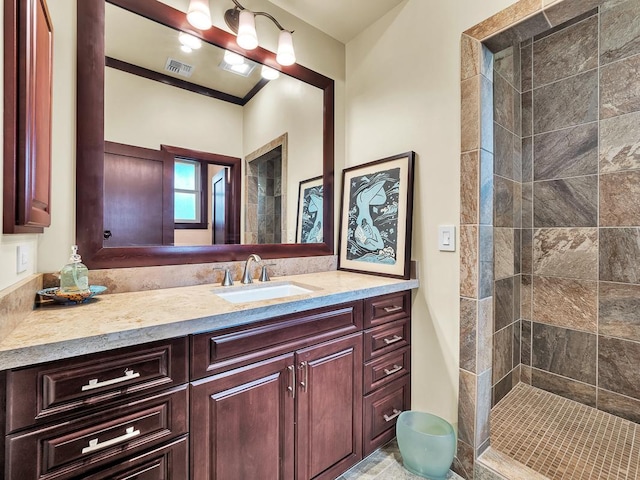 bathroom featuring a tile shower and vanity