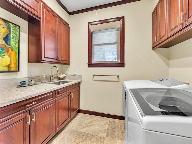 laundry room with cabinets, crown molding, sink, and washing machine and dryer