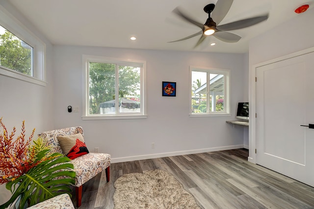 living area featuring hardwood / wood-style floors and ceiling fan