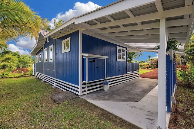 view of side of home featuring a yard and a carport