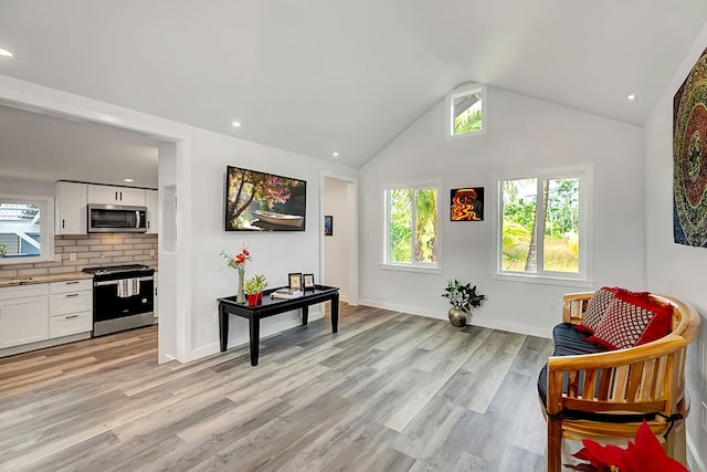 sitting room with light hardwood / wood-style flooring and lofted ceiling