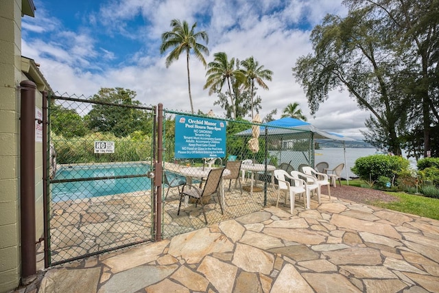 view of patio featuring a community pool and a water view