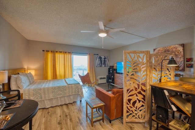 bedroom featuring ceiling fan, a textured ceiling, access to outside, and light wood-type flooring