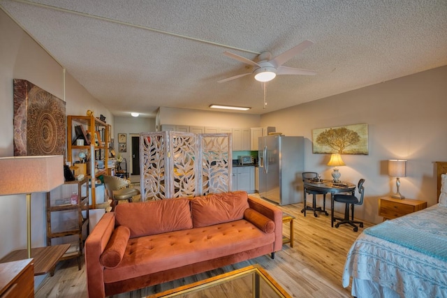 bedroom with ceiling fan, stainless steel fridge with ice dispenser, a textured ceiling, and light hardwood / wood-style flooring