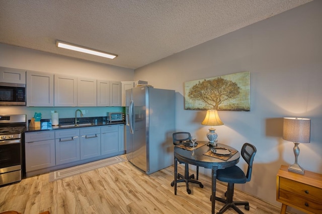 kitchen featuring appliances with stainless steel finishes, sink, and a textured ceiling