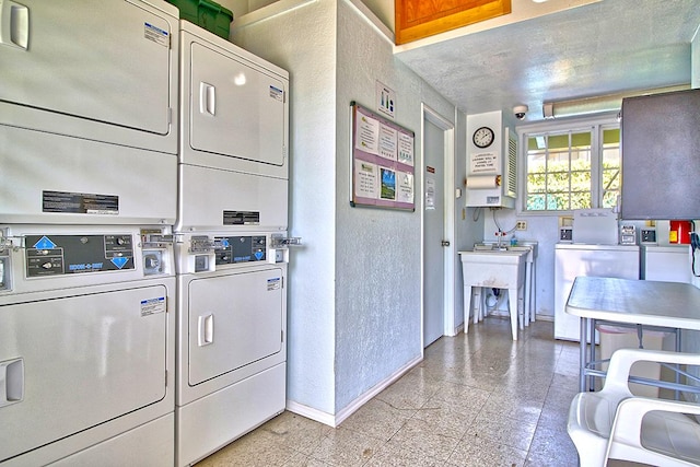 washroom with washer and dryer, stacked washing maching and dryer, and sink