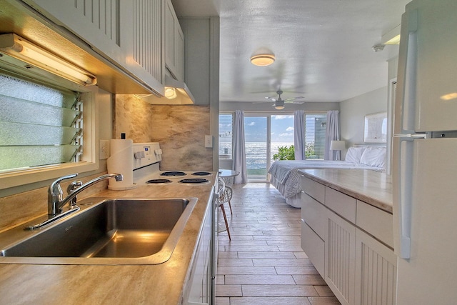 kitchen with white cabinets, white electric range, ceiling fan, and sink