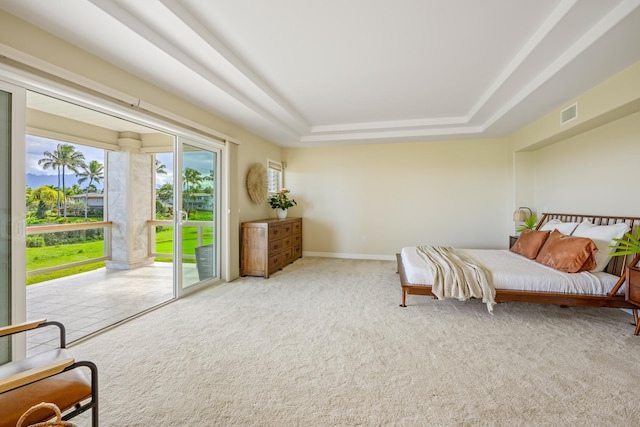 bedroom with carpet, a raised ceiling, and access to outside