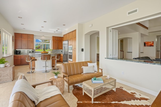 living room featuring light tile patterned floors and a healthy amount of sunlight