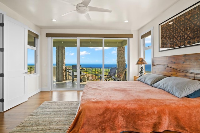 bedroom with access to exterior, a water view, ceiling fan, and light hardwood / wood-style floors