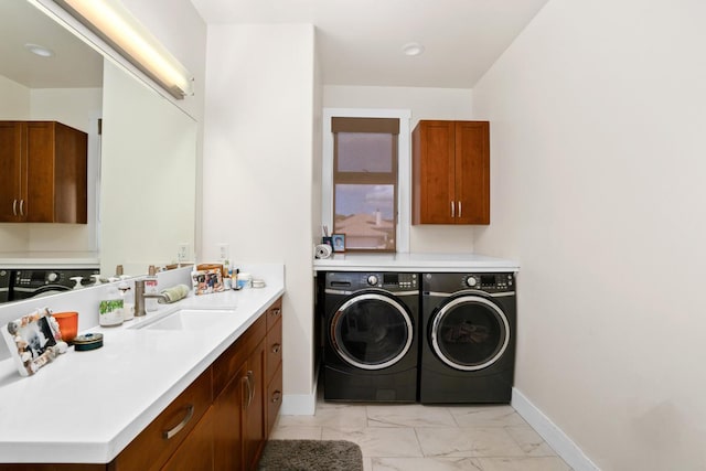 washroom with cabinets, sink, and washing machine and clothes dryer