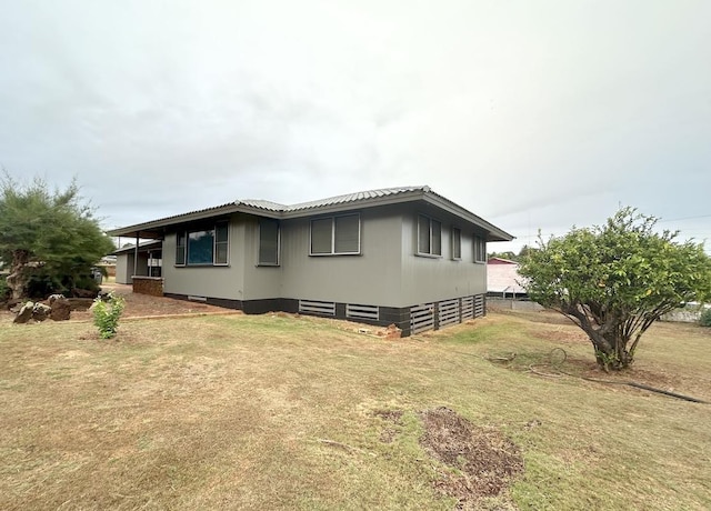 view of side of home with a yard