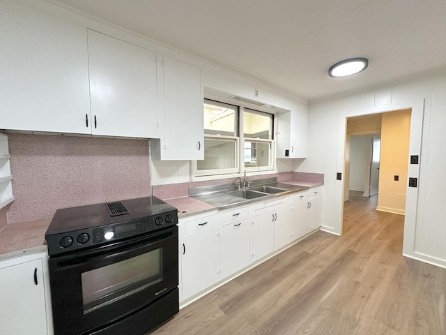 kitchen featuring backsplash, white cabinets, sink, black electric range, and light wood-type flooring