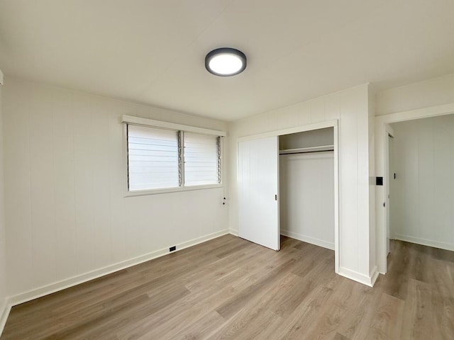 unfurnished bedroom with light hardwood / wood-style flooring and a closet