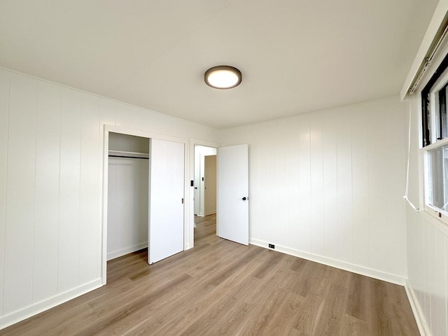 unfurnished bedroom with a closet and light hardwood / wood-style flooring