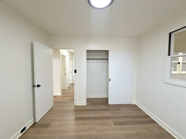 unfurnished bedroom featuring a closet and light hardwood / wood-style flooring