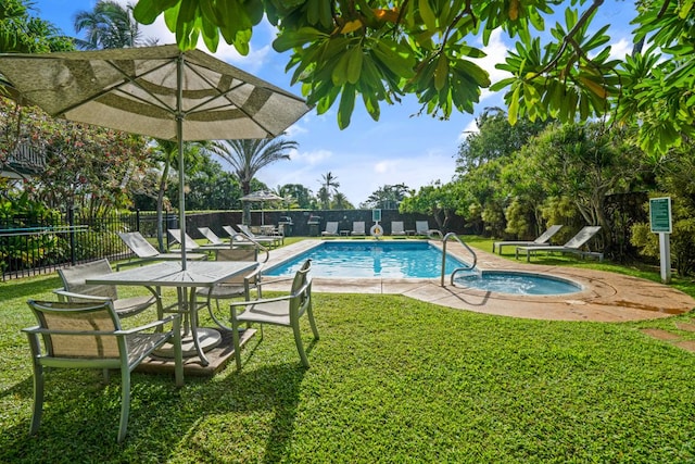 view of pool featuring a lawn, a patio, and a hot tub