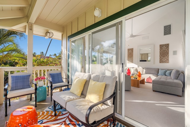 sunroom featuring a healthy amount of sunlight, ceiling fan, and lofted ceiling with beams