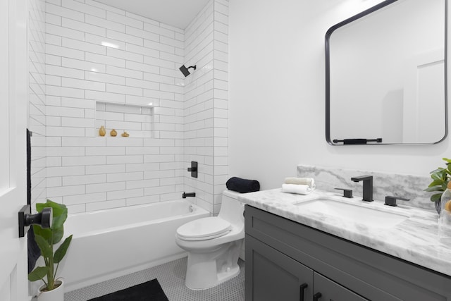 full bathroom featuring tile patterned flooring, vanity, tiled shower / bath combo, and toilet